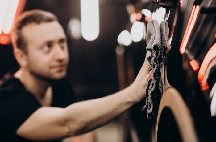 Echipă de detailing auto lucrând la un autoturism